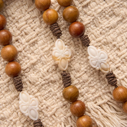 Naturalny zielony różaniec z koralikami z drzewa sandałowego z medalionem św. Benedykta w ramce z kwiatami i krucyfiksem