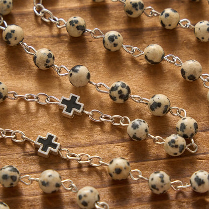 Naturalny kamień z krucyfiksem św. Benedykta, różaniec modlitewny: symbol modlitewnej ochrony i odkupieńczego miłosierdzia